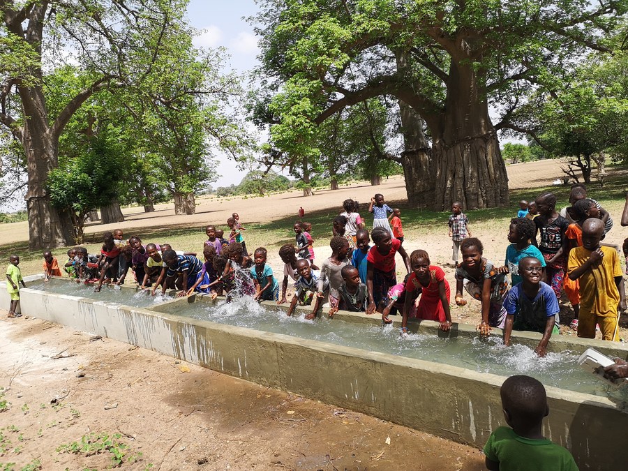 Children play beside a China-aided well in a village of Senegal, July 15, 2019. Photo by Xinhua.