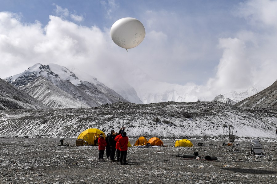 Scientific research members launch a balloon carrying radiosonde at the Mount Qomolangma base camp. Photo by Xinhua/Jiang Fan.