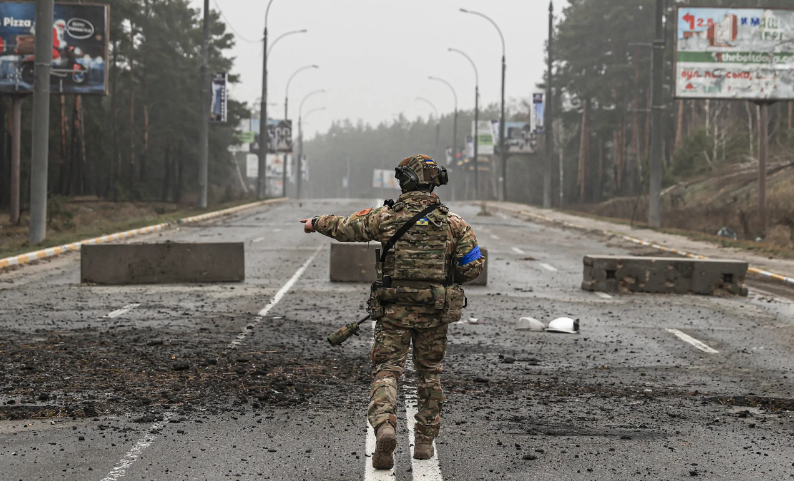 Украинский военный на Ирпенской трассе после побега российских войск из-под Киева, 1 апреля 2022 года, Ирпень, Украина. Фото: Metin Aktas/