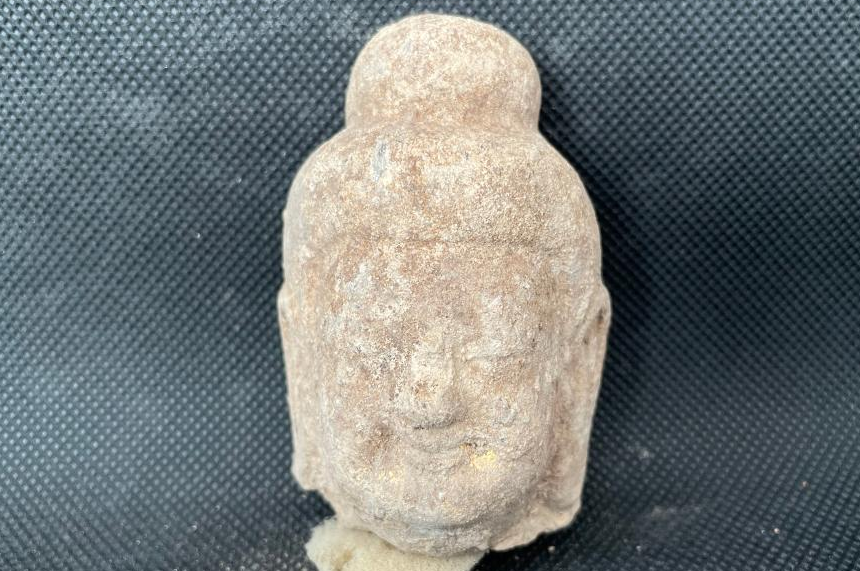 A stone Buddhist head unearthed at an ancient Buddhist temple dating back to the Northern Wei Dynasty (386-534) in Pingcheng District, Datong, north China's Shanxi Province. Photo by Xinhua.