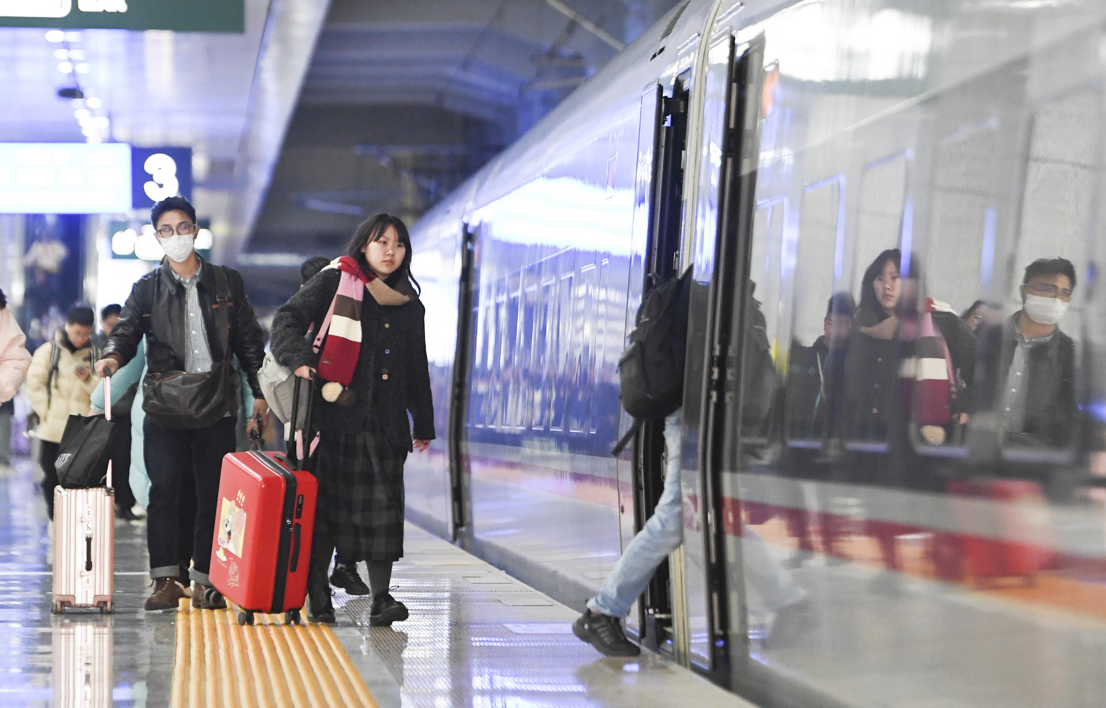 Passengers get aboard on a train at Shapingba Railway Station in southwest China's Chongqing.  Photo by Xinhua/Wang Quanchao.