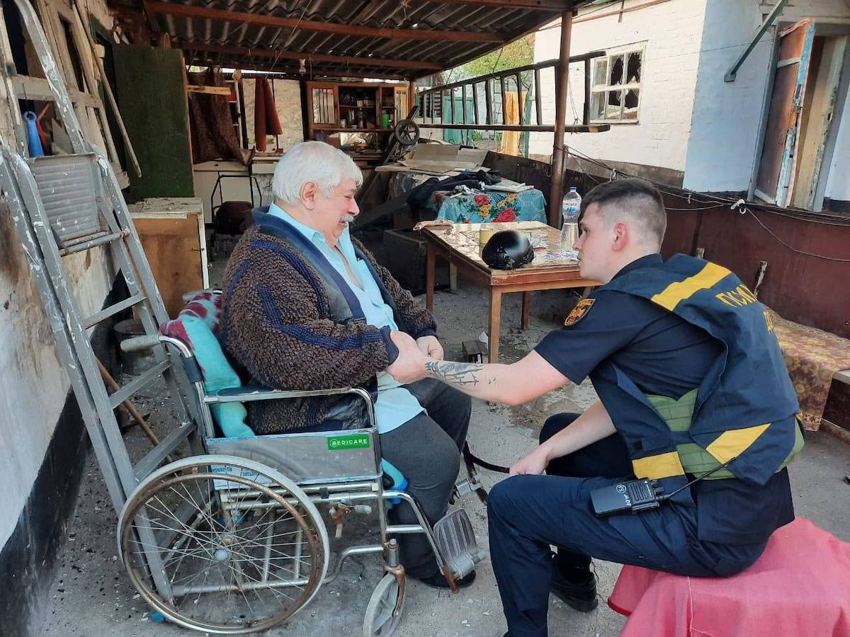 Психолог ДСНС працює з чоловіком, який постраждав від падіння уламків ракети окупантів. Фото: Дніпропетровська ОВА