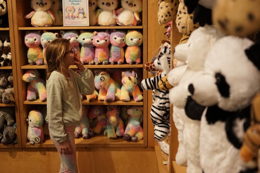 A girl visits a gift shop with giant panda-themed plushies at the San Diego Zoo in San Diego, California, the United States. Photo by Zeng Hui/Xinhua.