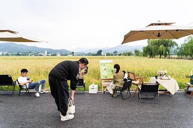 A customer takes a photo in the outdoor area of a village cafe in Doumu township of the city of Anqing, east China's Anhui province. Photo by Xinhua.