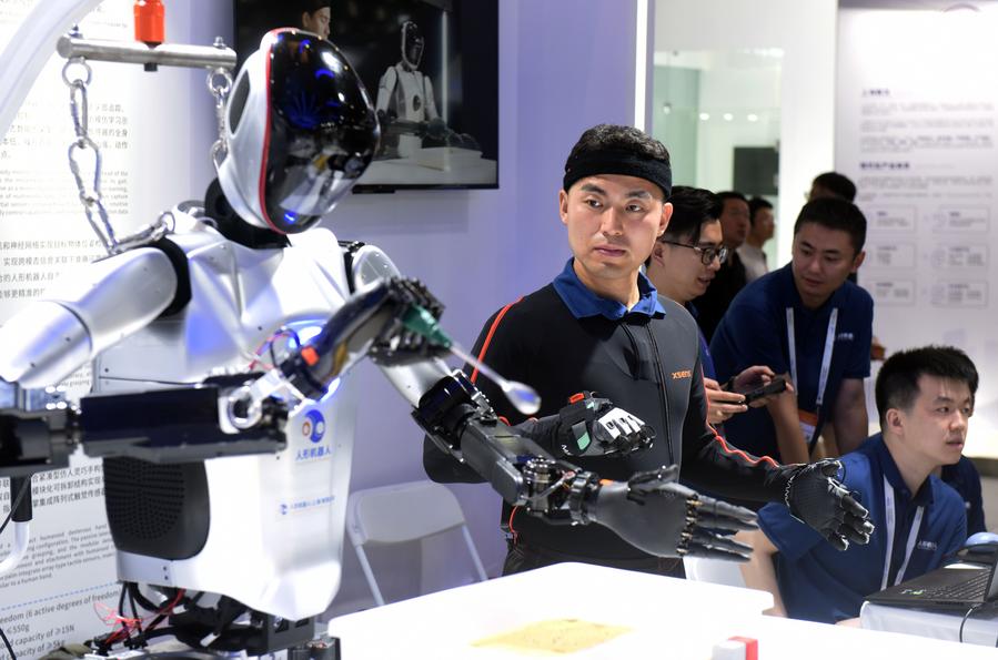 A staff member demonstrates a gesture-controlled robot during the 2024 World AI Conference in Shanghai, east China. Photo by Xinhua/Huang Xiaoyong.