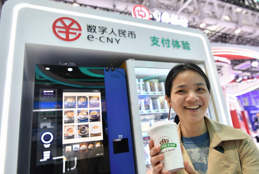 A visitor displays a cup of coffee purchased with China's digital yuan, or the e-CNY. Photo by Xinhua/Wei Peiquan.